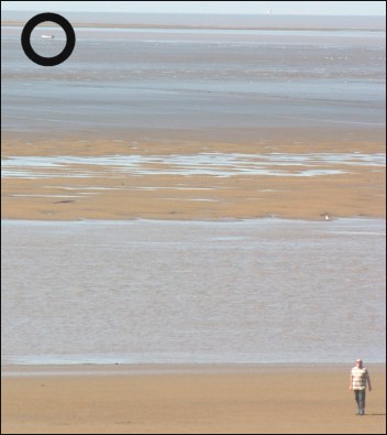 The stranded speedboat (circled) on mud flats at Stert