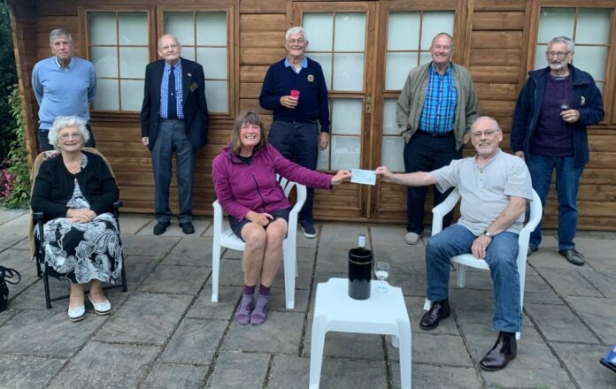 Burnham-On-Sea Rotary President Terry handing over a cheque donation of £100 to Karen Penny.