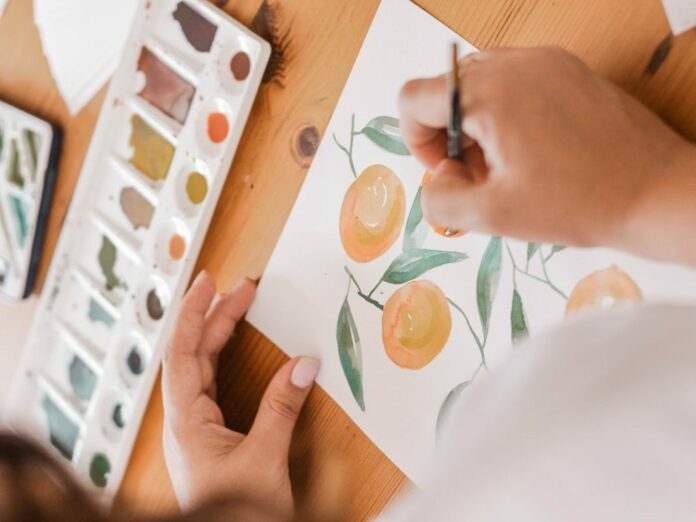 person painting a orange fruits