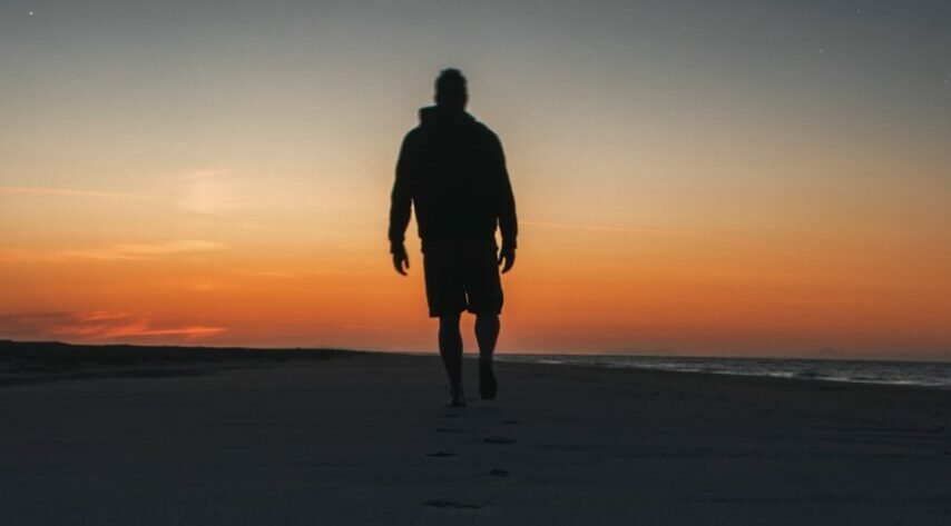 man walking on seashore