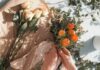 person holding orange fruit near green leaves