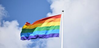 a rainbow flag flying high in the sky