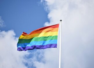 a rainbow flag flying high in the sky