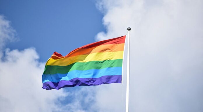 a rainbow flag flying high in the sky